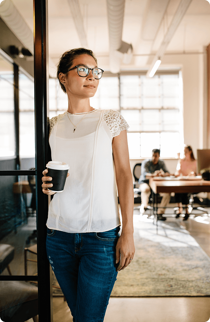 Portrait of happy woman standing in doorway of office