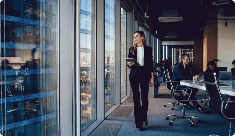 Business woman walking alongside windows
